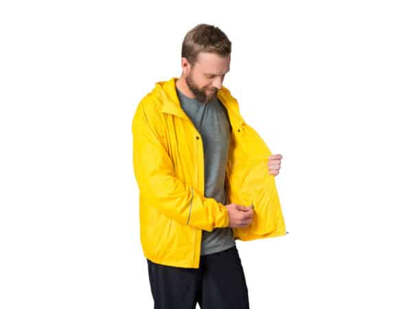 Miesmalli tarkastelee HANNAH Miles -vedenpitävän takin taskua, kuvattuna sivulta, kirkkaan keltainen.